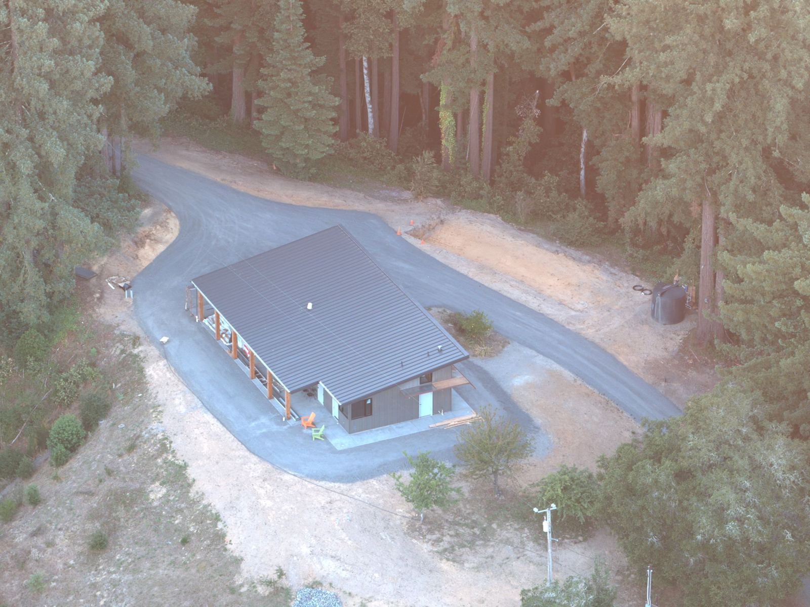 A new modern home on a graded lot among redwoods, seen from above